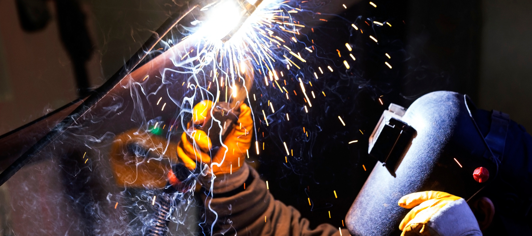 A welder actively working on metal